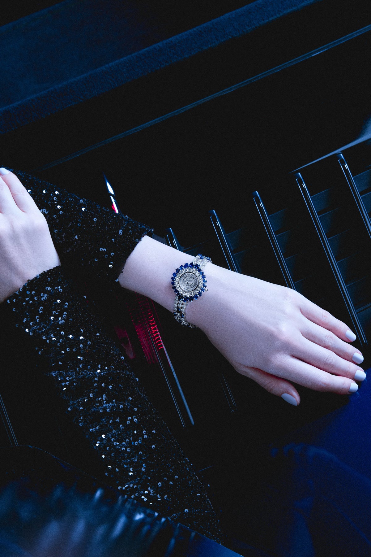 An Alain Philippe watch set with sapphires and diamonds, worn with a sequinned sleeve